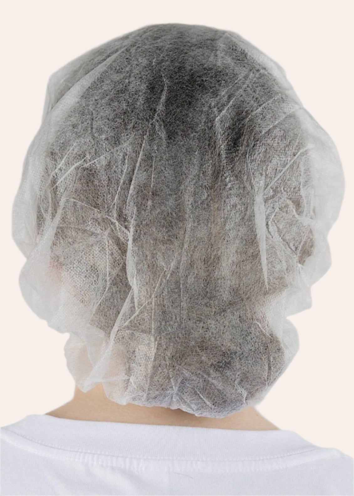 Back view of a white disposable bouffant hat covering the hair