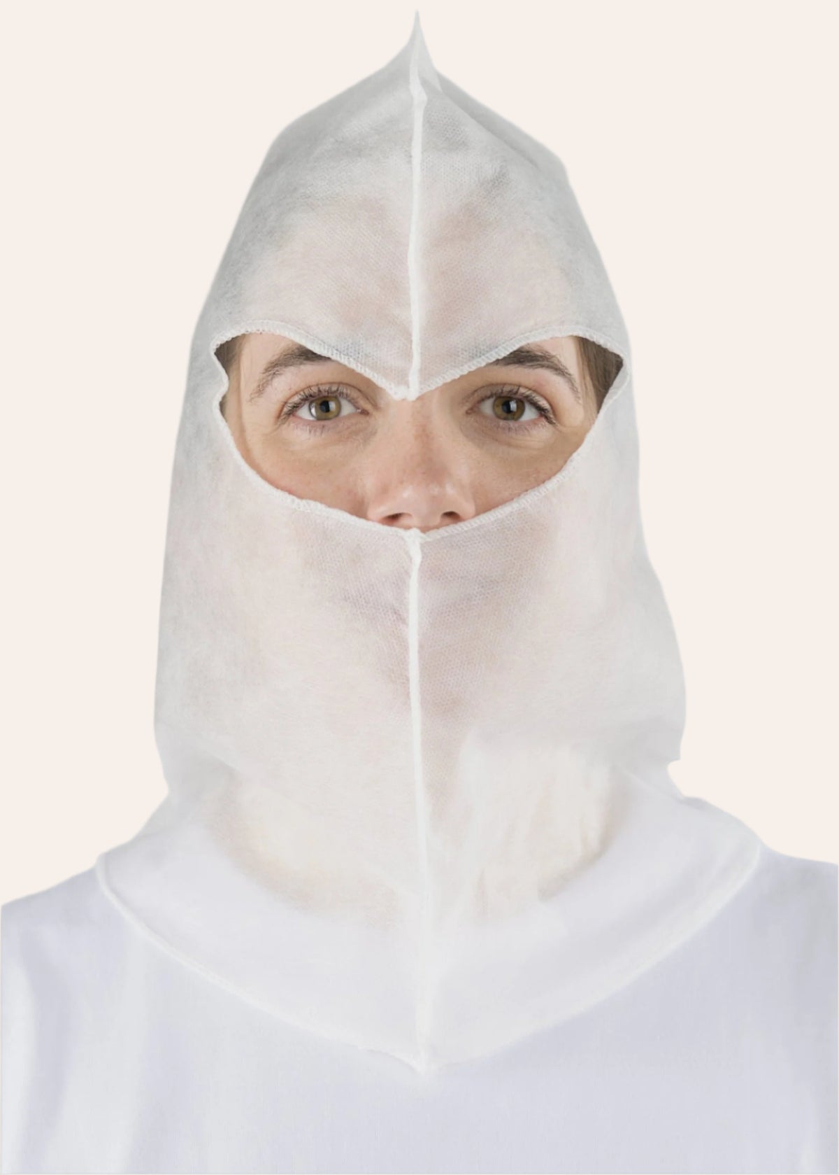 Woman wearing a white disposable closed face balaclava hood with an eye opening