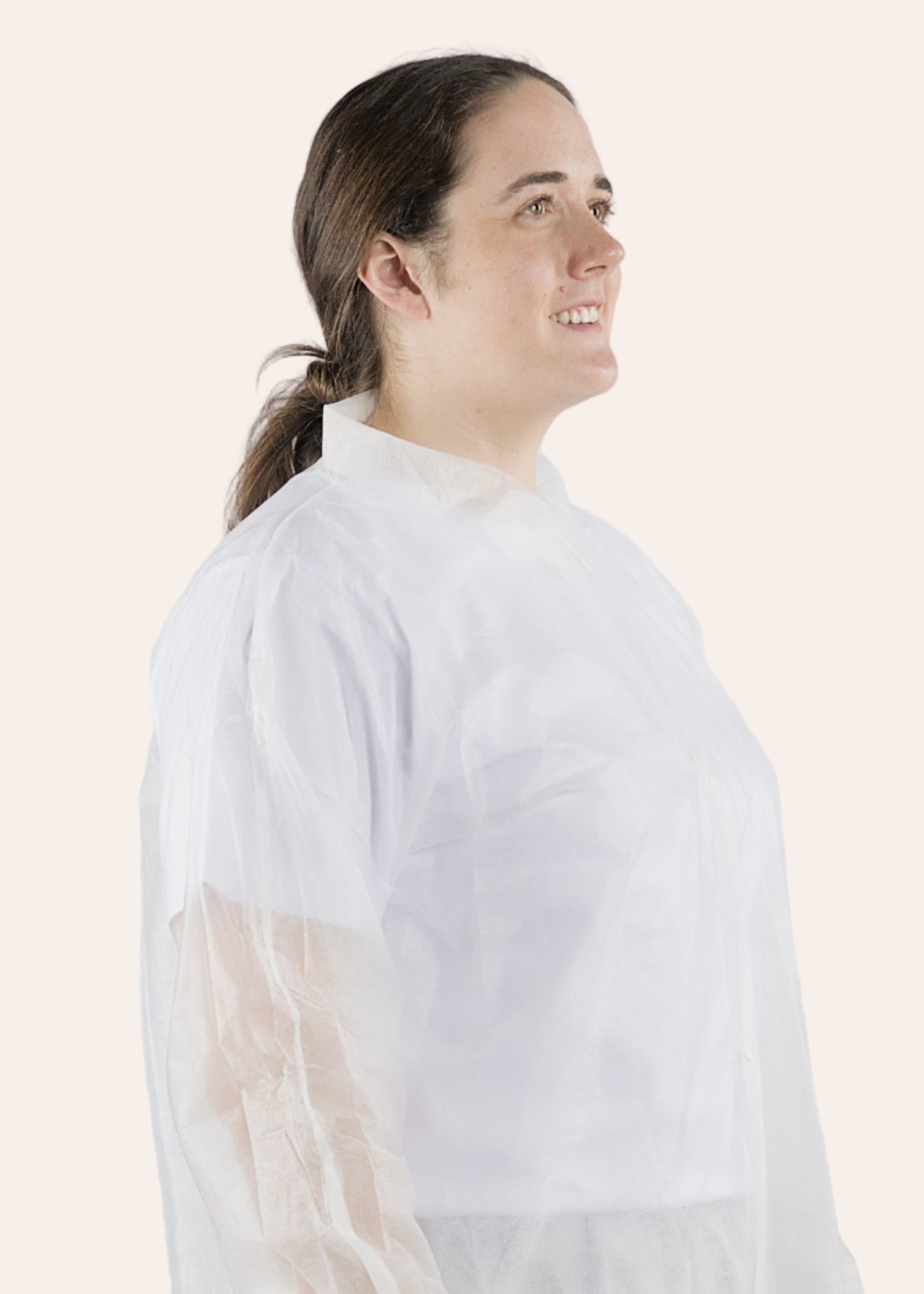 Woman wearing a white IDAS Group lab coat against a plain background